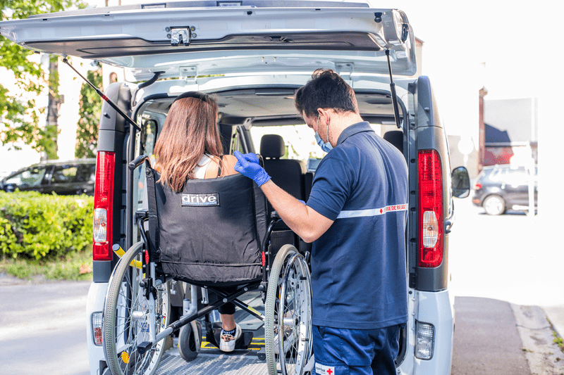 Bénévole qui aide au transport des personnes en situation de handicap moteur