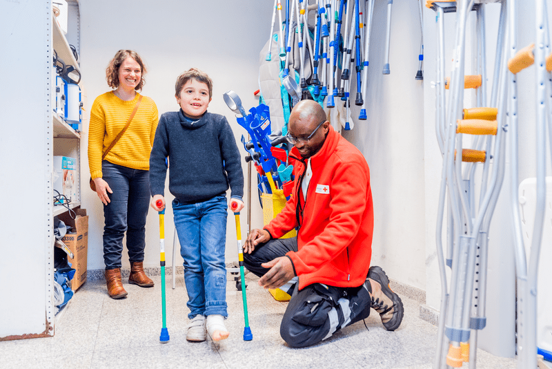Un garçon qui essaye des béquilles
