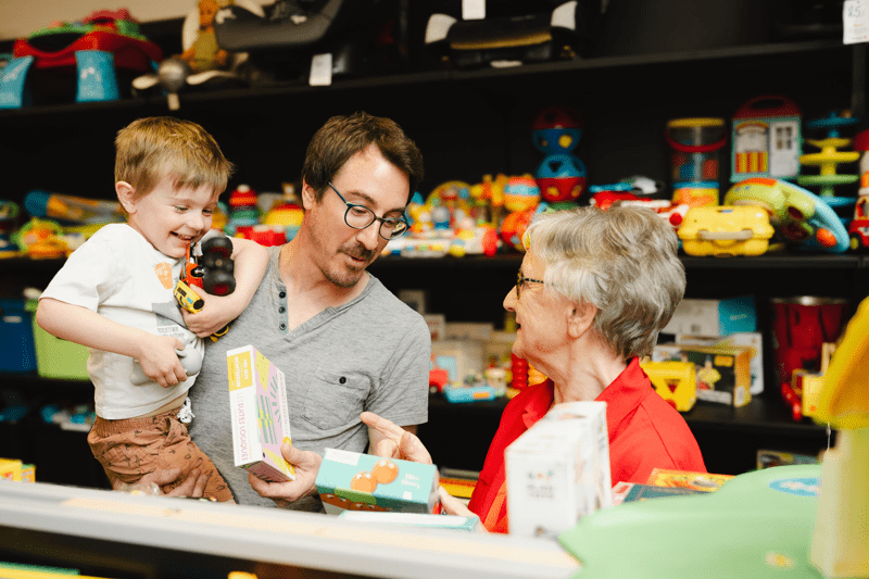 Un papa et son fils qui choisissent des jouets en brocante solidaire
