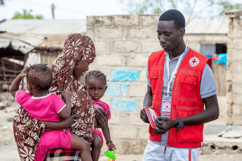 Un volontaire e la croix-rouge sénégalaise avec une famille