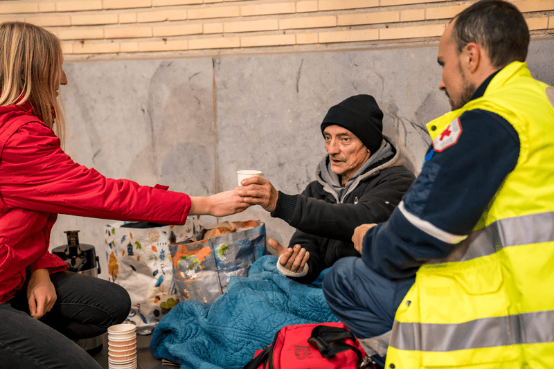 Deux volontaires et une personne sans-abri lors d'une tournée en rue