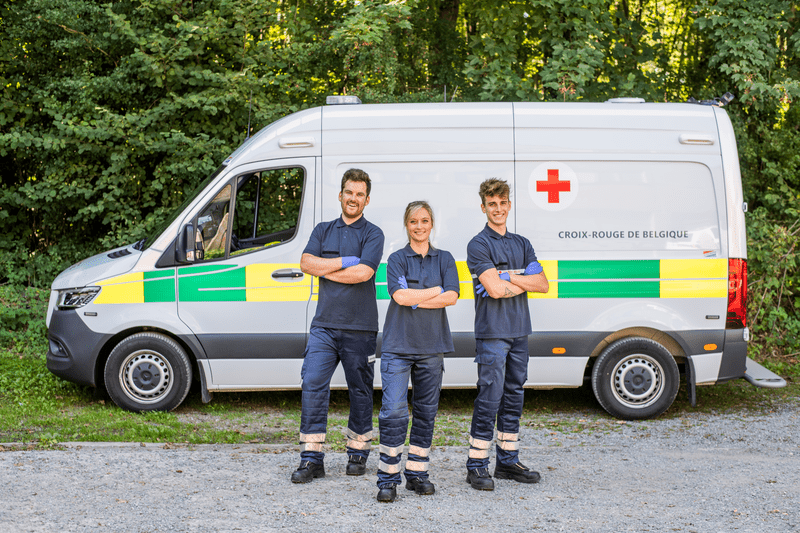 Des bénévoles devant une ambulances de la Croix-Rouge